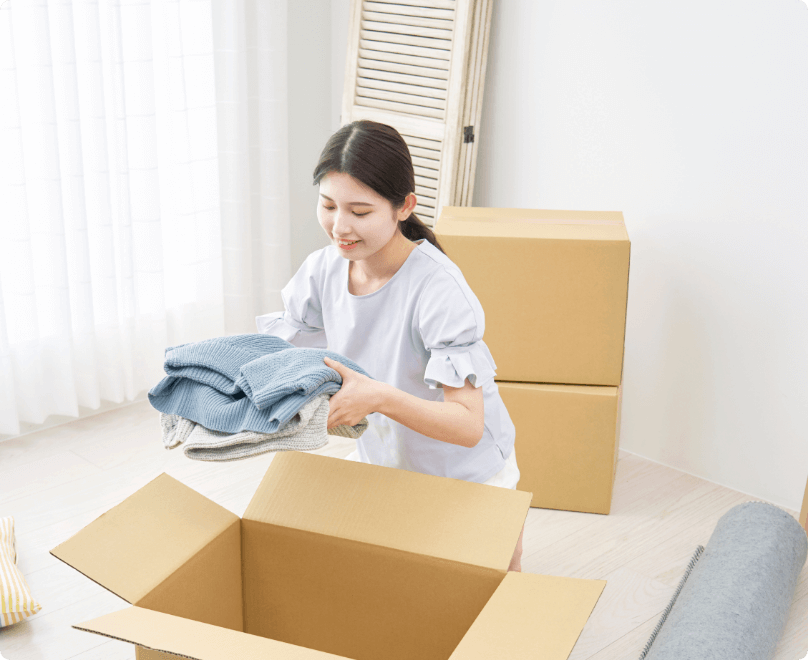 ダンボールにものを入れる女性